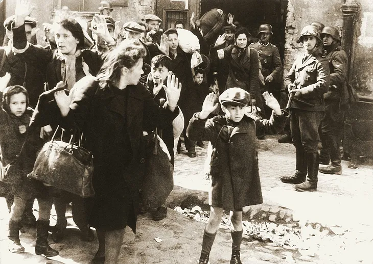 An image of jewish people being herded by German troops during World War II.
