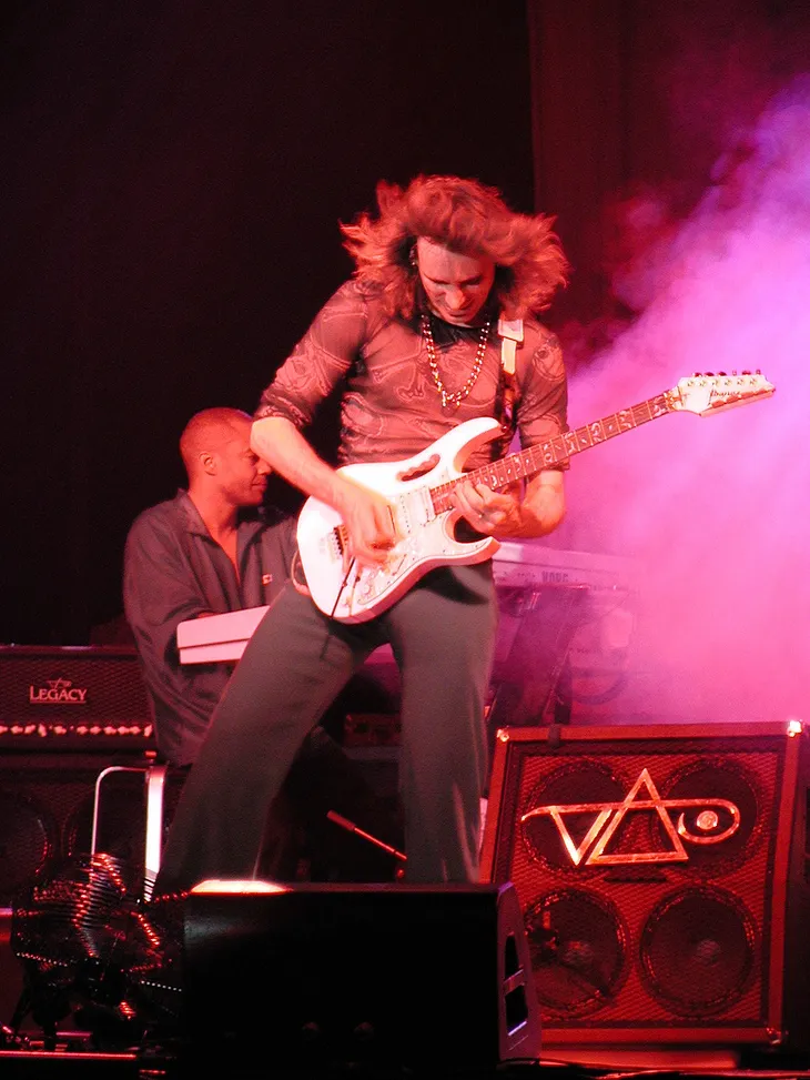 Steve Vai playing an Ibanez JEM guitar.