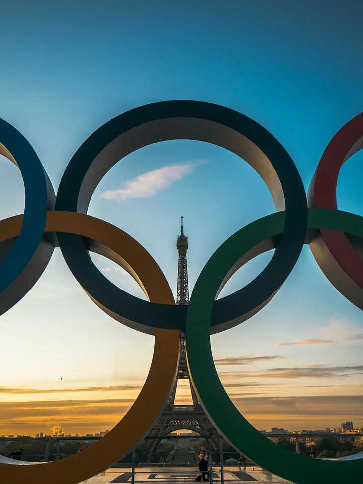 The Olympic Games rings with the Eiffel Tower in the background.