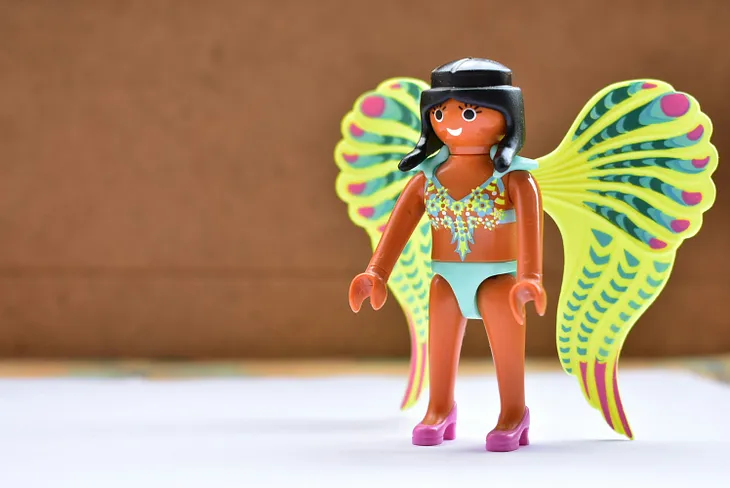 Photo of a tan-skinned Lego-like woman figure wearing a bikini and butterfly wings.