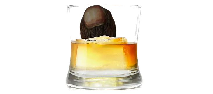 A glass of whiskey with a mummified toe in it