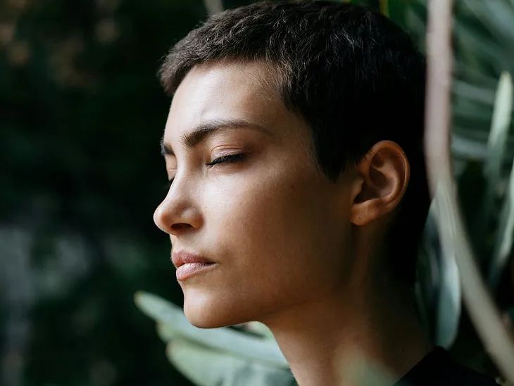 A short haired woman with eyes closed