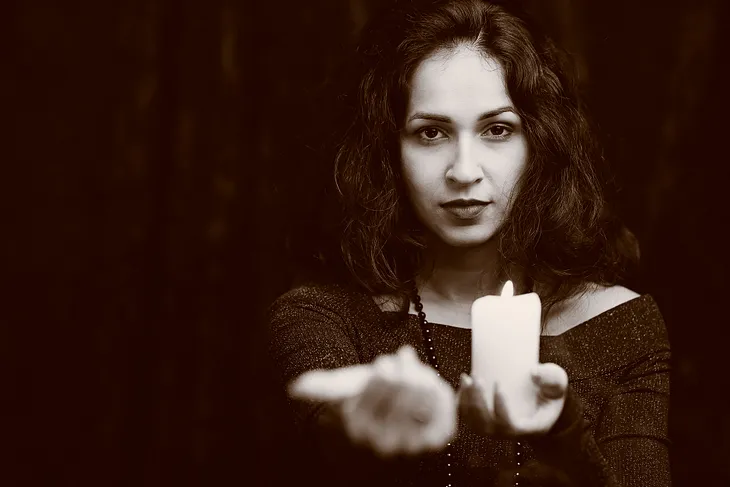 woman holding candle, beckoning. Envato Elements Item ID: YDDFP36. License available upon request.