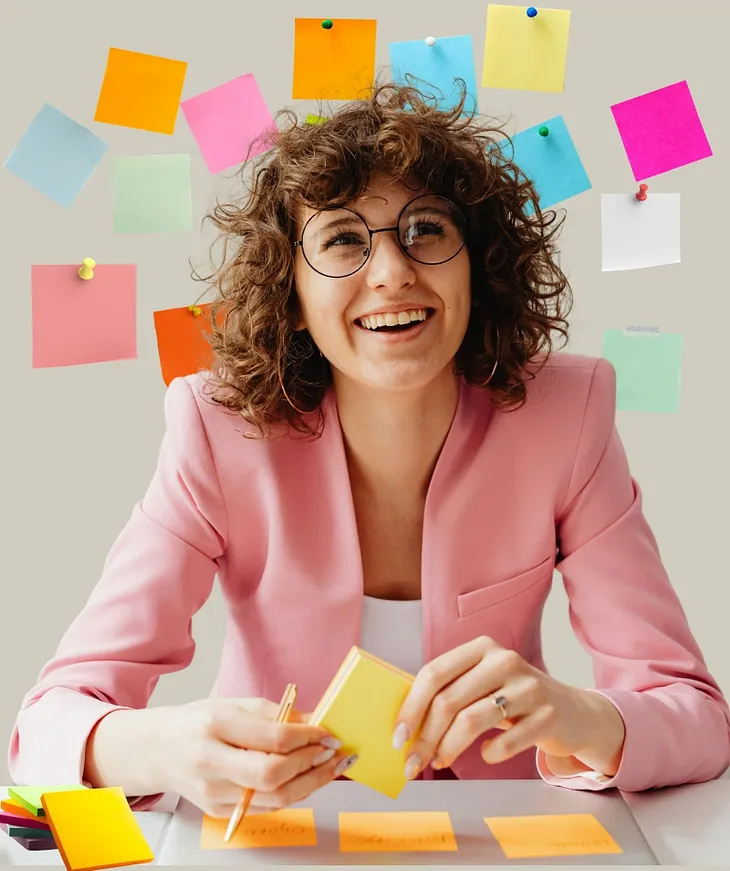 women sitting at a desk surrounded by sticky notes