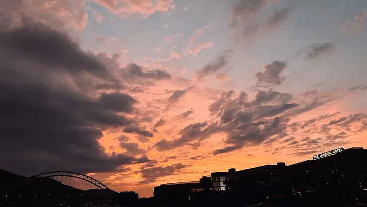 sunset with storm clouds moving into the view of the skyline.