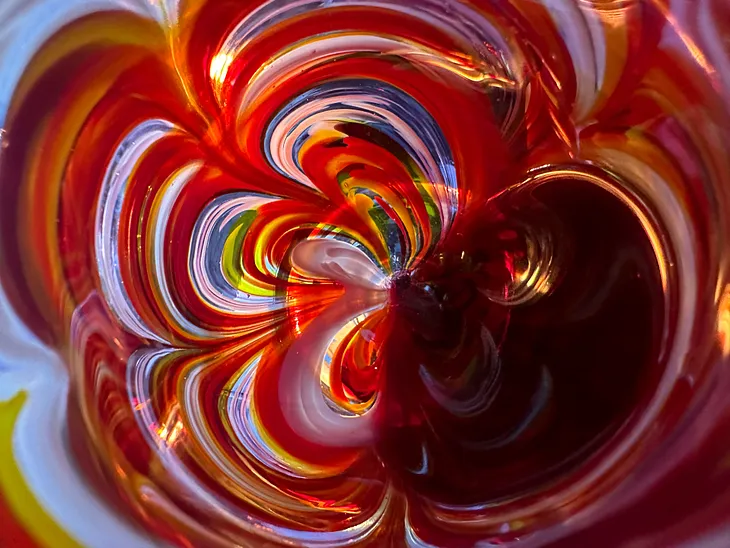 Sunset-inspired handblown wine glass. Orange, pink, yellow, and white mixed into the glass.