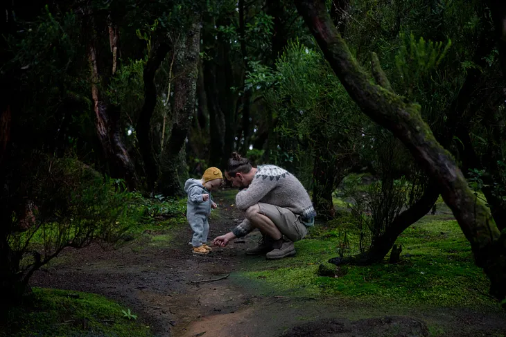 A father and son on the woods.