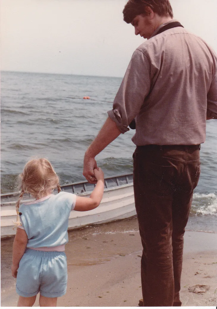 Vintage photo of the author as a child holding hands with their dad.