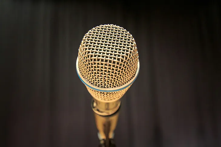 Golden microphone in front of a black curtain