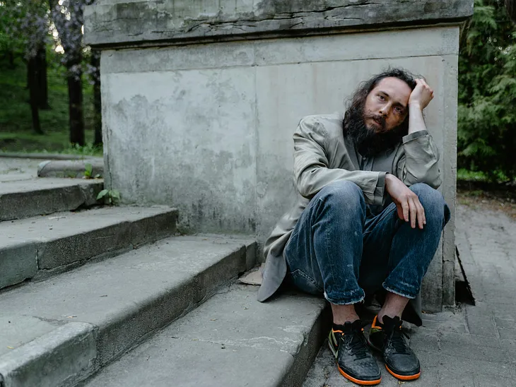 Homeless man sitting on steps