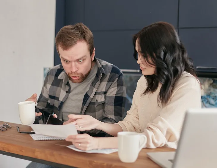 Shocked man looking at the paper. My wife suggested something crazy