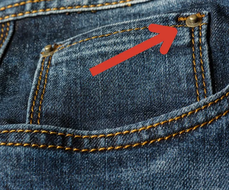 Why do jeans have small metal buttons?