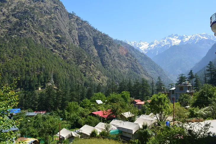 A wide view of Kasol camps with mountains behind