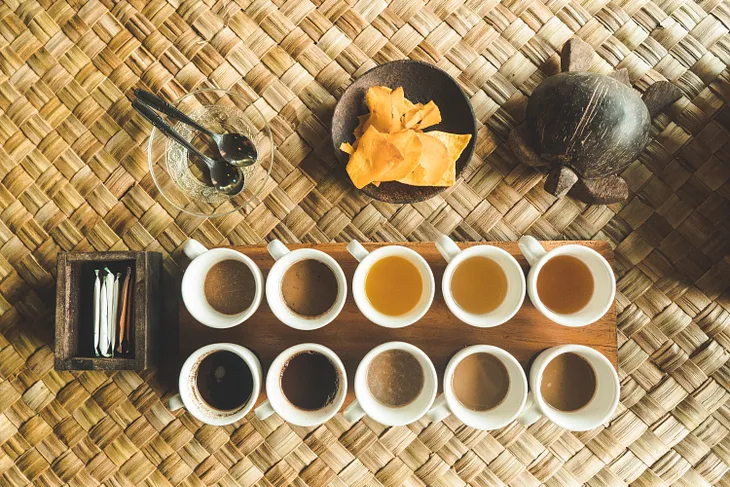 variety of drink samples on bamboo matt arranged in two rows for tasting