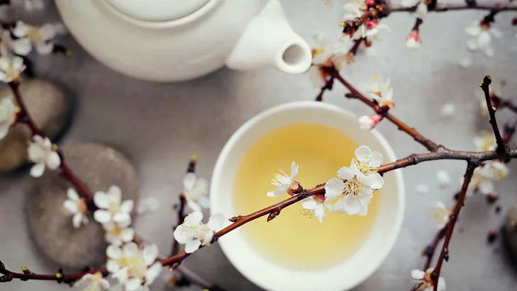 white tea in a cup with a tea pot