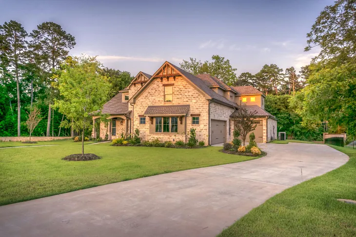 An appealing home with a large grassy yard and trees.