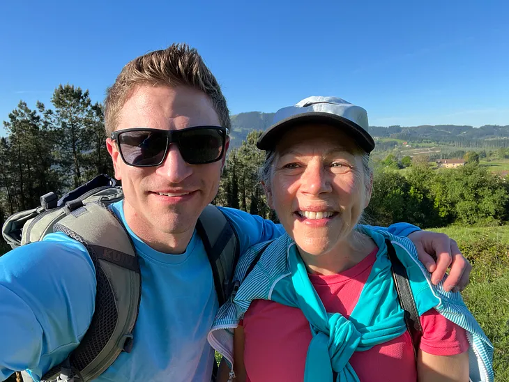 A selfie of my son and me, both smiling with hills in the background.