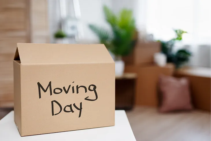 A moving box sits on a table with the words “Moving Day”