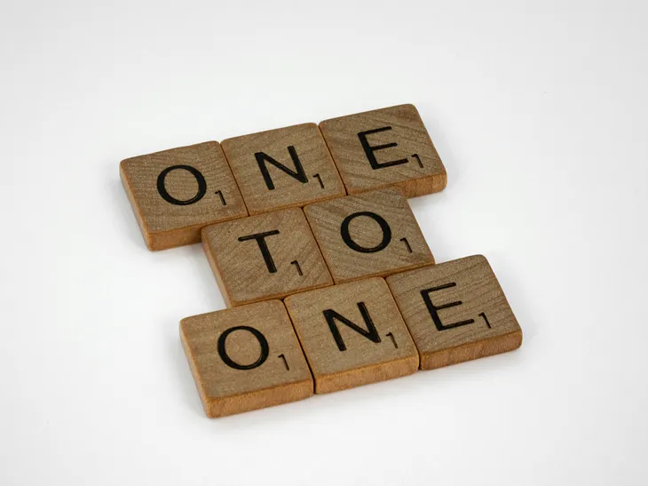 a photo of Scrabble tiles that spell “one to one”