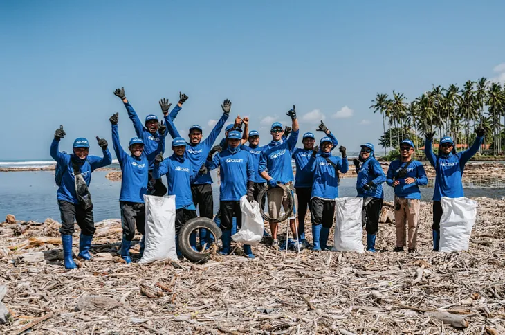 A group of workers posing together at the 4ocean Mewei Beach Cleanup.