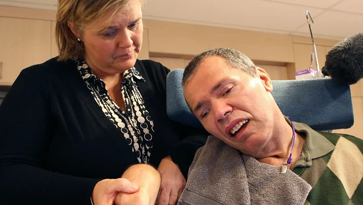 Rom Houben, a Belgian man who has been in a coma since 1983 is pictured with an assistant who is holding his hand and using it to operate a keyboard.