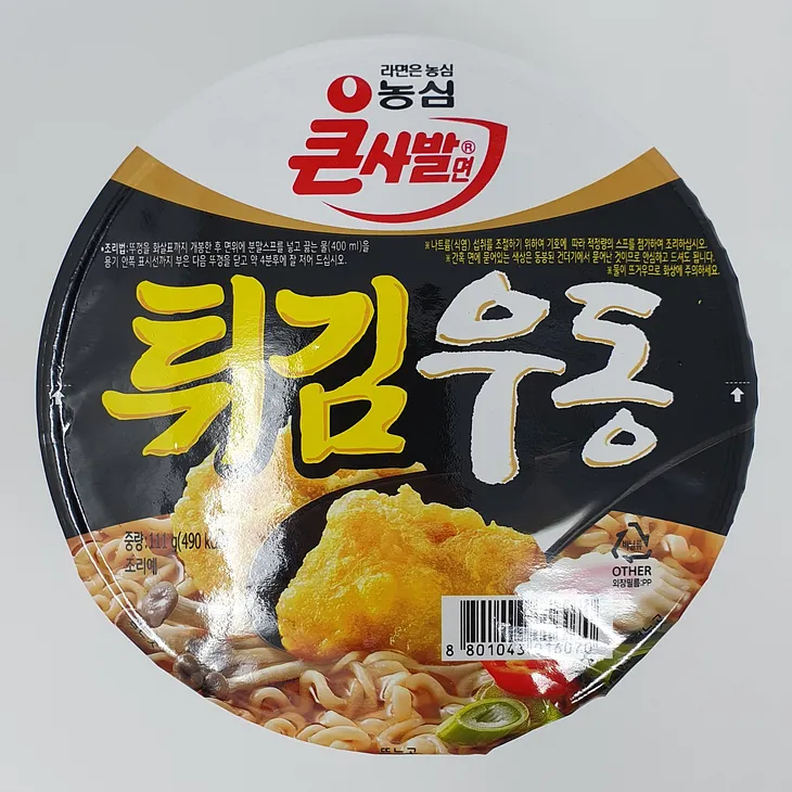 An unopened cup of Nongshim Fried Udon Instant Noodles.