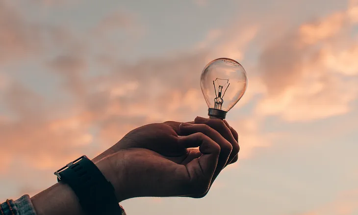 Representation of ideas — Hand holding a light bulb