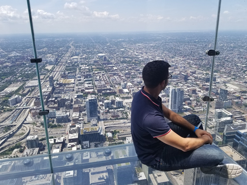 Man posing on a window overlooking the city.