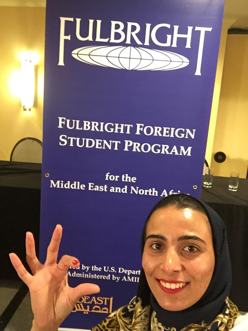 Woman posing with a Fulbrigh banner.