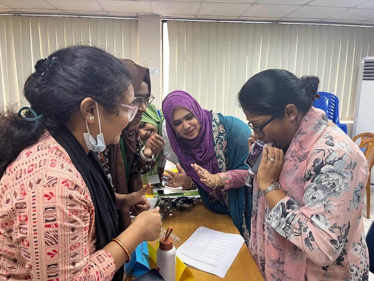 Dr. Rukaeya Amin Sobi performs a spirometry breath test while surrounded by fellow team members during a training session at icddr,b. Photo credit: Hiba Babiker