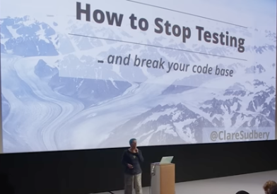 Clare speaking during this video — big screen in background