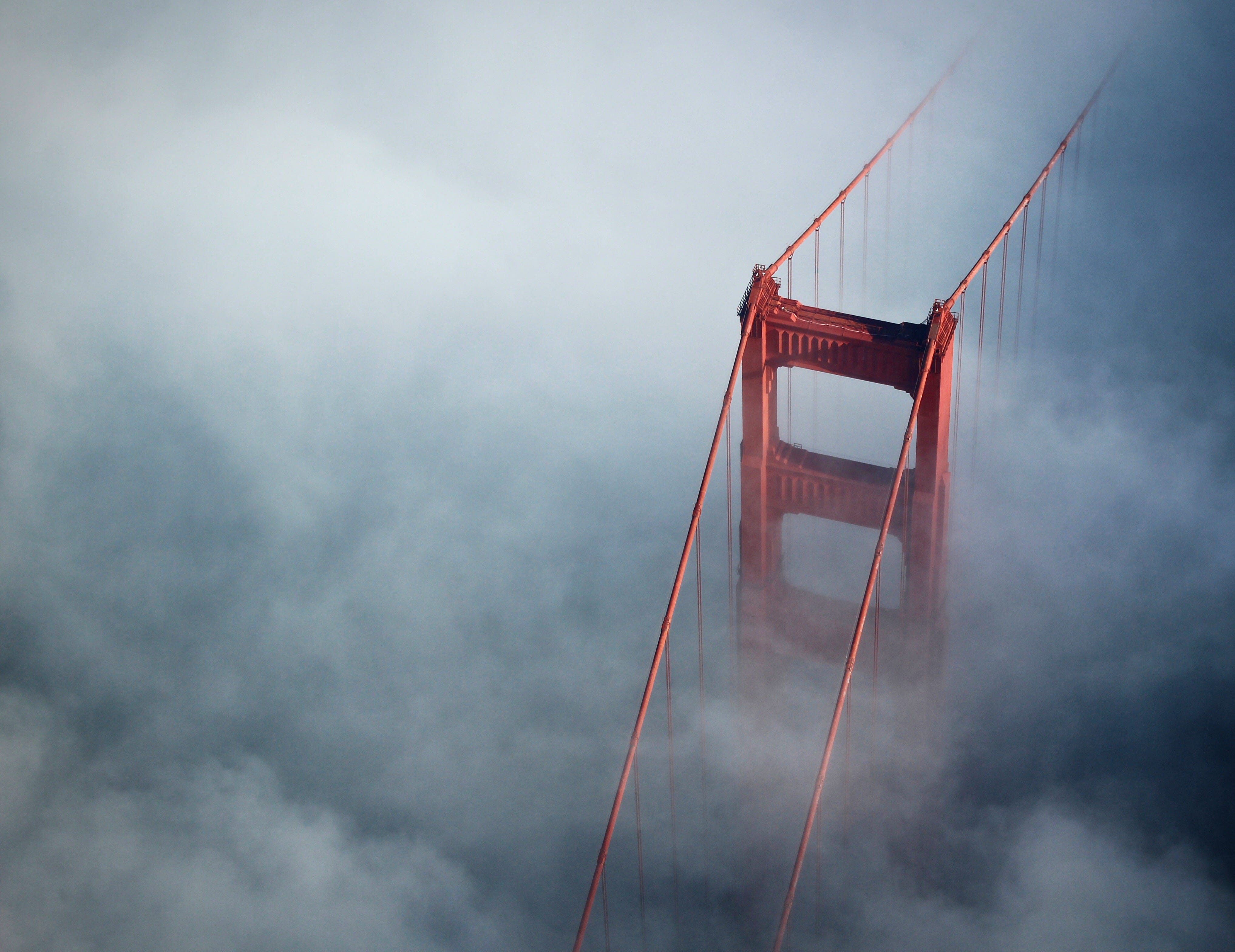 A shot of the Golden Gate Bridge in the fog, taken from an aircraft.