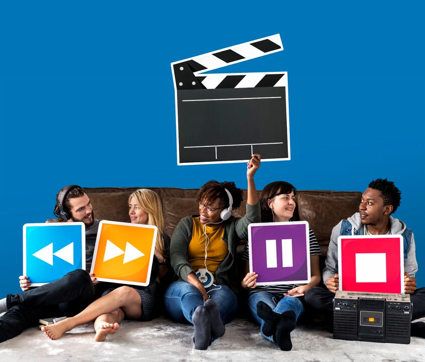 'a group of people sitting on a couch holding up signs'
