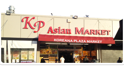 The exterior of KP Asian Market, which has a red awning over the entrance which says, “Koreana Plaza Market.”