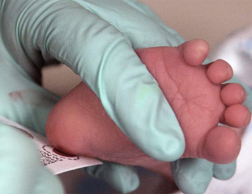 A healthcare worker collects a few drops of blood from a pinprick to a newborn’s heel for use in a test to screen the baby for an inherited disorder. — Image: U.S. Air Force photo/Staff Sgt Eric T. Sheler — USAF Photographic Archives