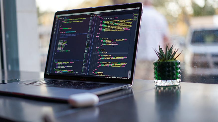 computer on a desk with code on the screen