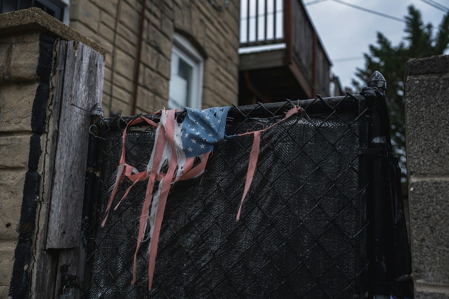 A tattered and discarded American flag — Photo by Gayatri Malhotra on Unsplash
