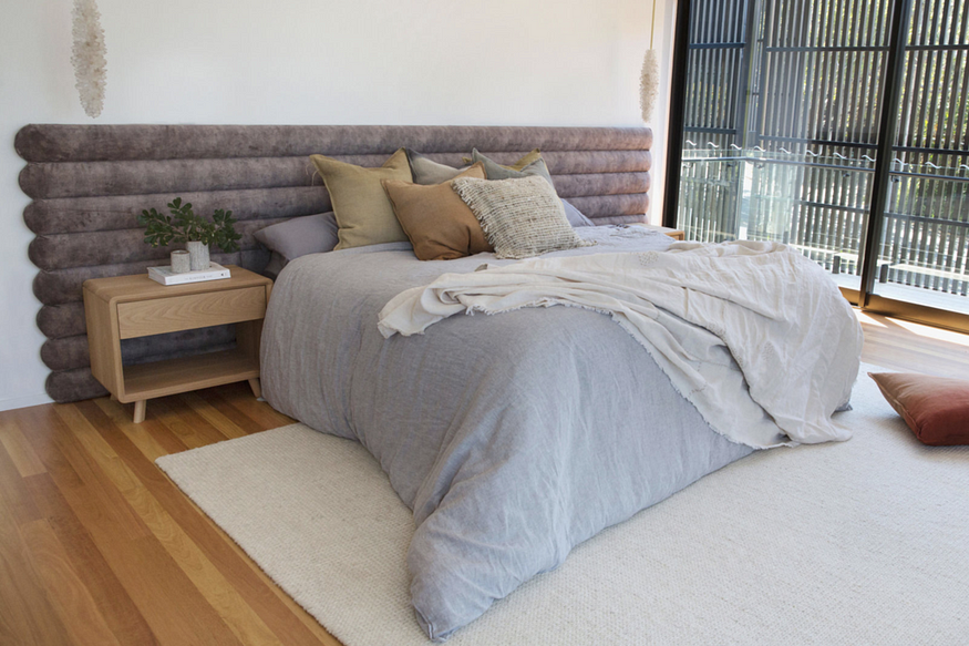 Une superbe chambre principale avec une tête de lit cannelée de 4 mètres de long dans un velours champignon moelleux