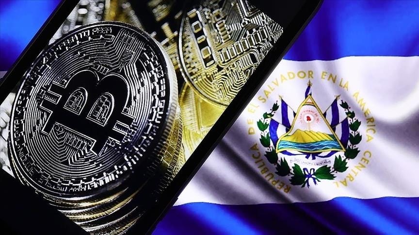 There is a flag of El Salvador and a few coins of the Bitcoin on this picture.