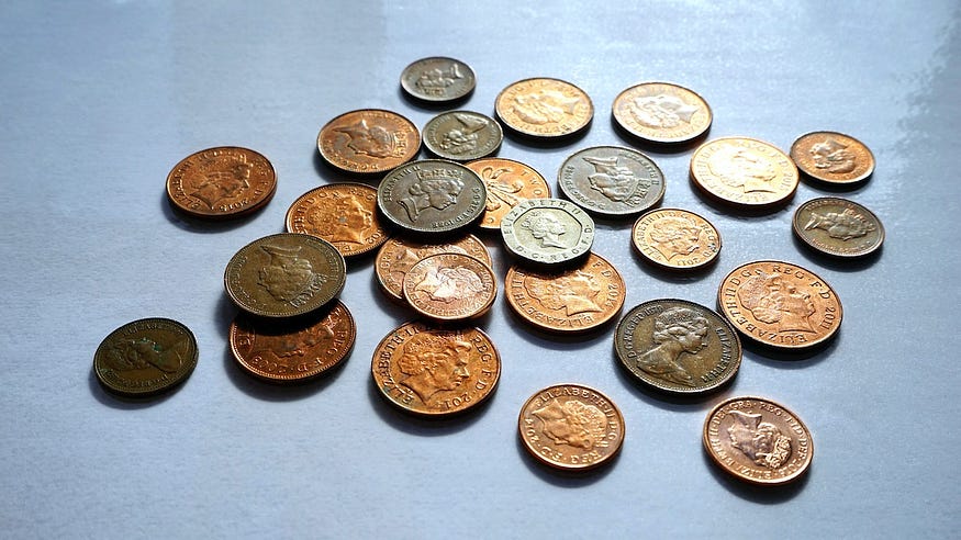 A Counterintuitive Fiat Money Arbitrage — A bunch of old coins laid on the table