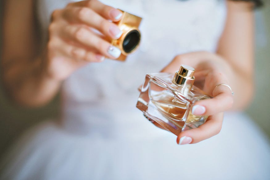 A bride with white dres holding perfume bottle.Source — Black friday brand https://blackfridaybrand.com/