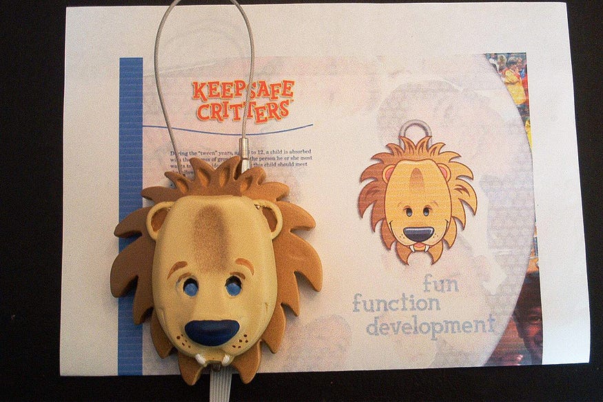 A lion-faced padlock prototype resting on a printed brand sheet labeled “Keepsafe Critters,” with the words “fun function development” and an illustrated version of the product visible in the background.