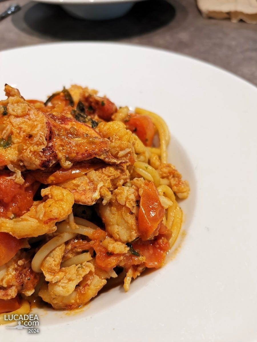 Un piatto di spaghetti con aragosta e pomodorini
