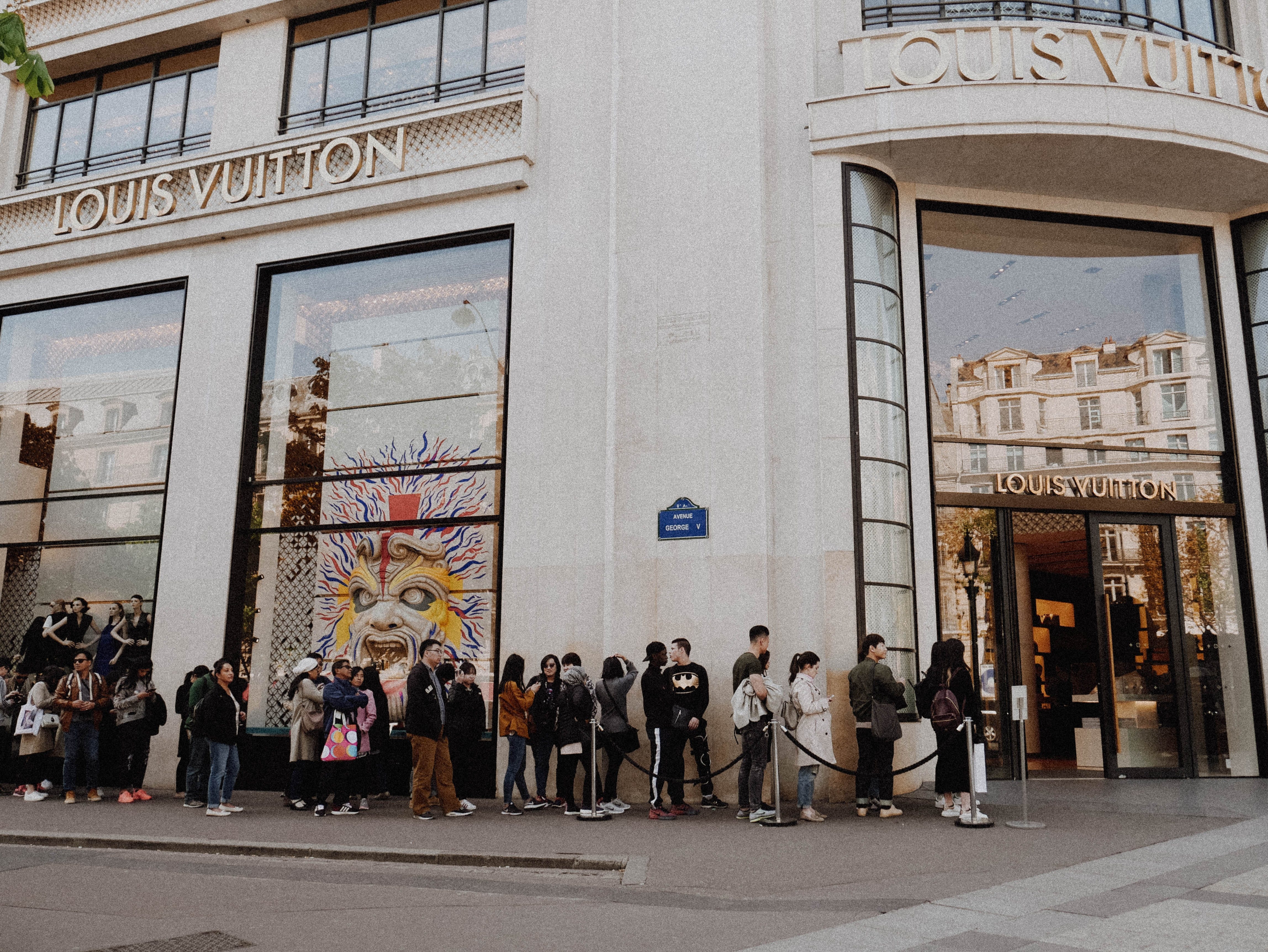 PARIS-APR 14: Customers are on queue to enter Louis Vuitton shop at Champ  Elysee avenue