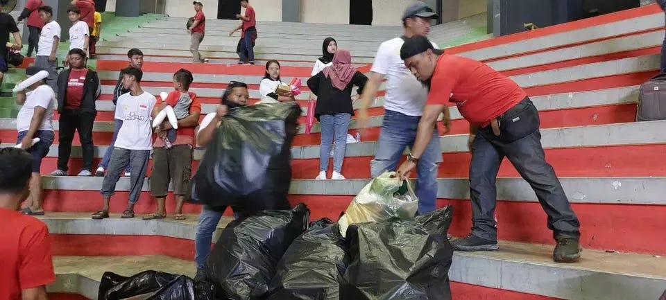 Bersih-bersih sampah suporter BIN usai pertandingan Livoli Divisi Utama 2023 di Kediri, Jawa Timur. Anis Firmansah/Beritasatu